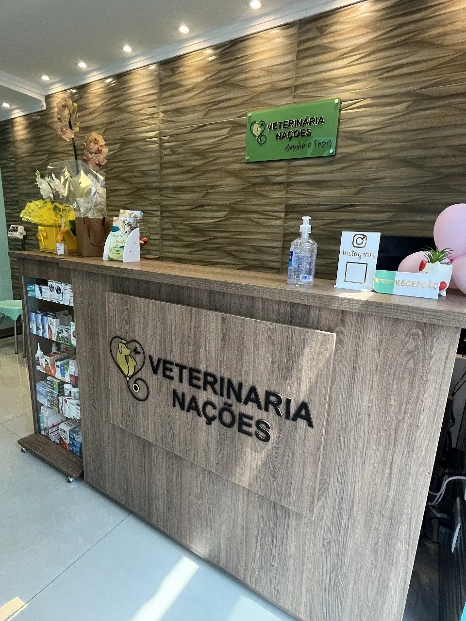 Balcão de recepção da Clínica Veterinária Nações, com a marca aplicada na frente